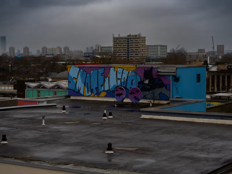 A London rooftop painted with a mural, the city skyline low on the horizon