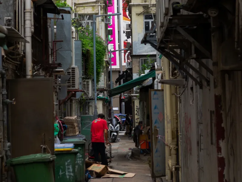 A narrow Hong Kong side street framed by shop signage and scaffolding