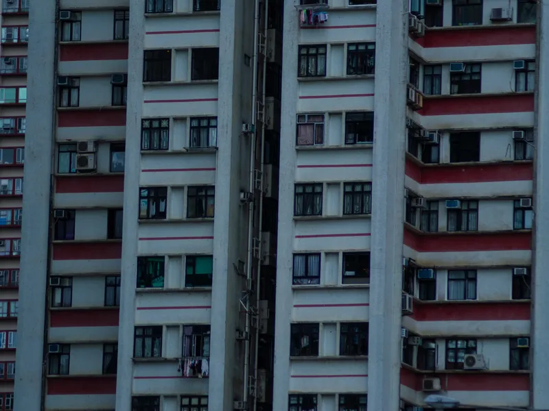 A red and white apartment facade, balconies repeating across the frame