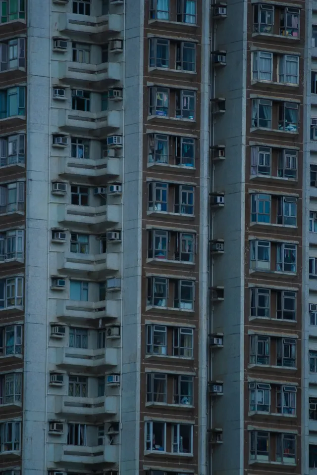 A pale tower block seen from below, windows running to the top of the frame